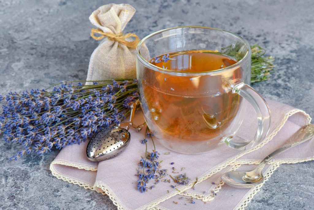 glass cup of tea on napkin with fresh lavender and teabag